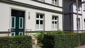 een zwart-wit huis met een groene deur bij Ferienwohnung Sundkieker in Stralsund