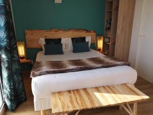 a bed with a wooden headboard and pillows at Les Secrets Château Pey La Tour in Salleboeuf