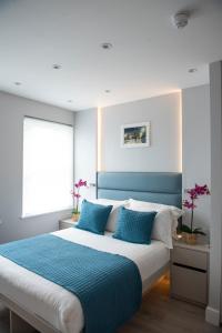 a bedroom with a large bed with a blue headboard at NOX West Hampstead in London