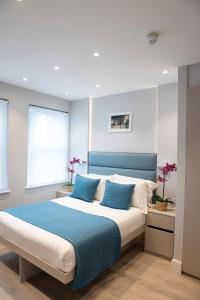 a bedroom with a large bed with blue accents at NOX West Hampstead in London