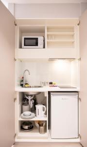 uma cozinha com armários brancos e um micro-ondas em NOX West Hampstead em Londres