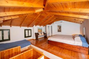 a bedroom with two beds in a room with wooden ceilings at Ionian Seaview apartments in Syvota