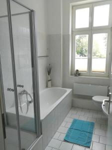 a white bathroom with a tub and a window at Ferienwohnung Sundkieker in Stralsund +8 photos