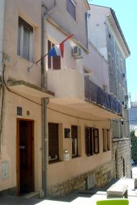 a building with a flag on the side of it at Apartments Popov in Crikvenica
