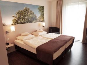 a bedroom with a large bed and a large window at Das Neue Hotel Am Park in Fröndenberg