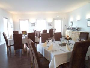 comedor con mesa y sillas con mantel blanco en Das Neue Hotel Am Park en Fröndenberg