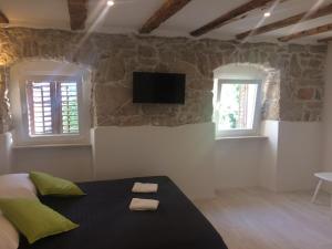 a bedroom with a bed and a tv on the wall at Apartment Relax in Rijeka