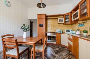 małą kuchnię z drewnianym stołem i krzesłami w obiekcie OhMyHome - Kościuszki w Łodzi