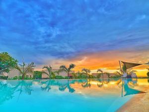 a large swimming pool with a sunset in the background at Vipingo Ridge-Swahili Villa in Mombasa
