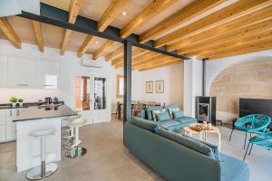 a living room with a blue couch and a kitchen at CASA OASIS in Pollença