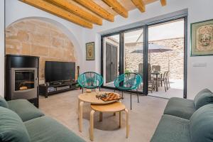 a living room with a couch and chairs and a tv at CASA OASIS in Pollença