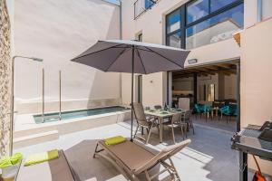 a patio with an umbrella and a table and chairs at CASA OASIS in Pollença