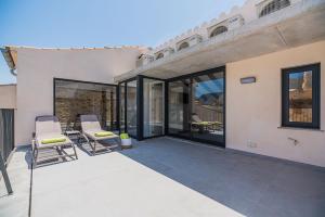 a patio with two chairs and sliding glass doors at CASA OASIS in Pollença