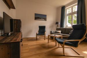 uma sala de estar com um sofá e uma televisão em Ferienwohnung Sundkieker em Stralsund