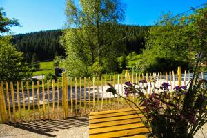 a wooden bench sitting in front of a fence at Black Forest Apartements by Hotel Grüner Baum Feldberg in Feldberg