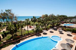 widok z lotu ptaka na basen ośrodka wypoczynkowego z palmami i oceanem w obiekcie Apartamentos Be Suites Primera Linea w mieście Oropesa del Mar