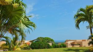 a group of palm trees in front of a building at Vipingo Ridge-Swahili Villa in Mombasa