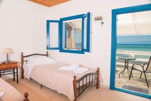 a bedroom with a bed and a view of the ocean at Julie's Hermes house in Skala Kallirachis