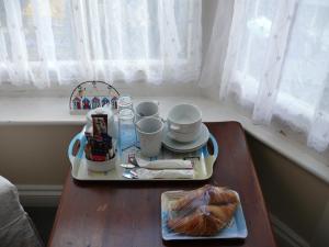 uma mesa com uma bandeja com chávenas e um prato de comida em Bow Street Runner em Brighton & Hove