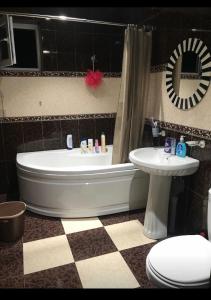 a bathroom with a tub and a toilet and a sink at Apartment on Grishashvili 1 in Batumi