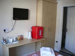 a kitchen area with a refrigerator, microwave, and coffee maker at Bow Street Runner in Brighton & Hove