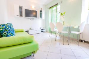 a living room with a green couch and a table and chairs at Apartment Ivana in Makarska