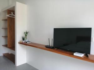 een flatscreen-tv zittend op een muur bij Christelle Inn in Panglao