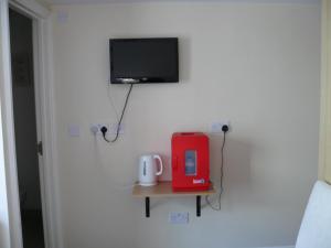 um quarto com uma televisão e uma mesa com comodidades para preparar café em Bow Street Runner em Brighton & Hove