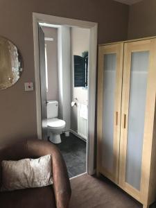 a bathroom with a toilet and a chair in it at The Shepherd's Rest in Alnwick