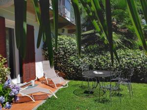 eine Terrasse mit Stühlen und einem Tisch im Hof in der Unterkunft Casa Maria Teresa in Cannero Riviera