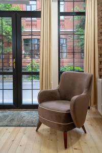 a brown chair sitting in front of a window at Wine Inn Borjomi Aparthotel in Borjomi