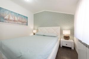 een slaapkamer met een wit bed en een schilderij aan de muur bij Castua-apartment with private heated pool in Kastav