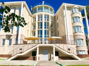 an apartment building with stairs and umbrellas at Hotel Minin on Pozharskogo Street in Nizhny Novgorod