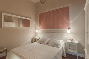 a bedroom with a white bed and a mirror at Ricasoli Charme in Florence