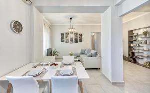a dining room and living room with a white table and chairs at Angel's Spirit Apartment in Zakynthos Town