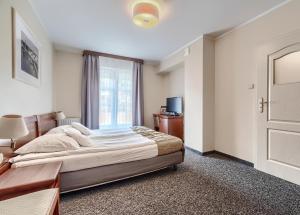 a bedroom with a large bed and a window at Villa Palladium in Gdańsk