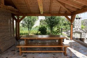 a wooden pavilion with a picnic table and benches at Castua in Kastav