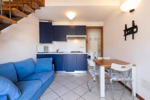 un soggiorno con divano blu e tavolo di Appartamento Via Roma a Stresa
