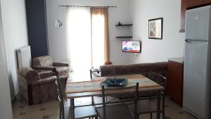 a living room with a table and chairs and a kitchen at Apartment with Sea View... in Samos