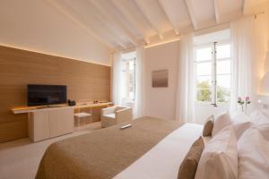 a bedroom with a large bed and a television at Can Simoneta - Adults Only in Canyamel