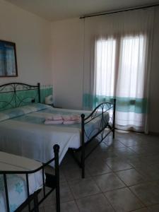 a bedroom with two beds and a window at Hotel Il Platano in San Teodoro