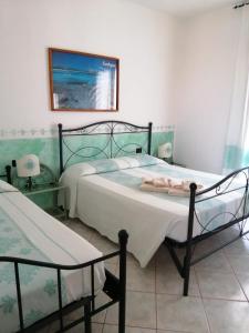 1 dormitorio con 2 camas y una foto en la pared en Hotel Il Platano, en San Teodoro