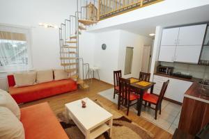 a living room with a couch a table and a staircase at Apartamenty Międzymorzem in Krynica Morska