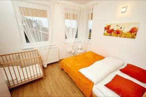 a bedroom with a bed and two windows at Apartamenty Międzymorzem in Krynica Morska