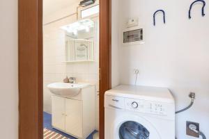 bagno con lavatrice e lavandino di Appartamento Via Roma a Stresa