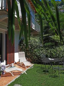 eine Terrasse mit 2 Stühlen und einem Tisch im Hof in der Unterkunft Casa Maria Teresa in Cannero Riviera