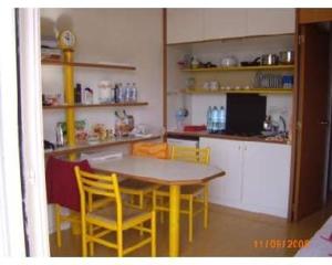 uma cozinha com uma mesa e cadeiras amarelas num quarto em Residence Pianeta Maratea em Maratea