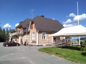a house with a black roof and a car parked in front at Wanhan Aseman Majatalo in Savonlinna