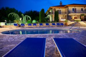 a swimming pool with blue chairs and a house at Villa Plattensee in Vonyarcvashegy