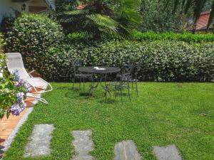 einen Tisch und Stühle in einem Garten mit Gras in der Unterkunft Casa Maria Teresa in Cannero Riviera